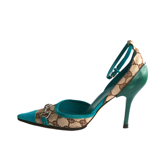 Teal high-heeled shoe with Gucci pattern on a white background
