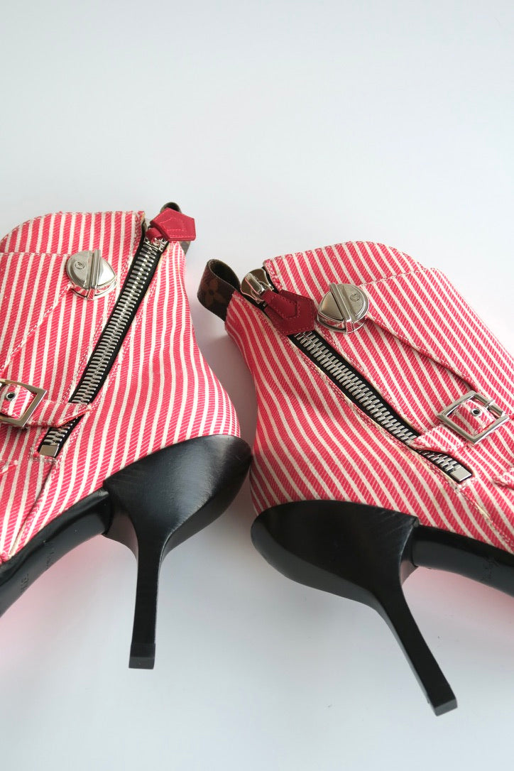 Red and white striped high-heeled shoes with zippers on a white background