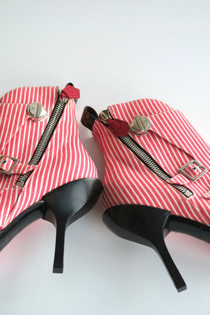 Red and white striped high-heeled shoes with zippers on a white background
