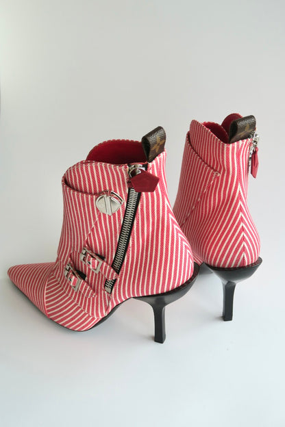 Red and white striped high-heeled boots with zippers on a light gray background