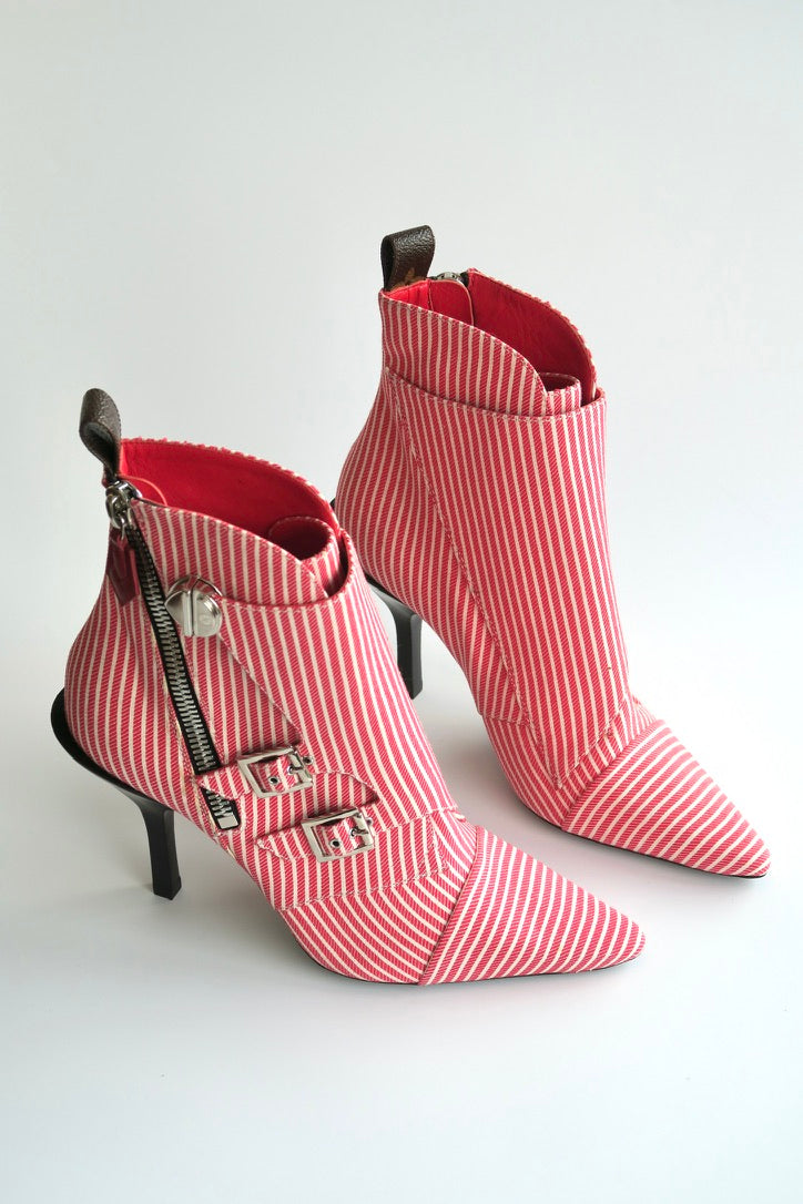 Red and white striped high-heeled boots with zippers on a light gray background
