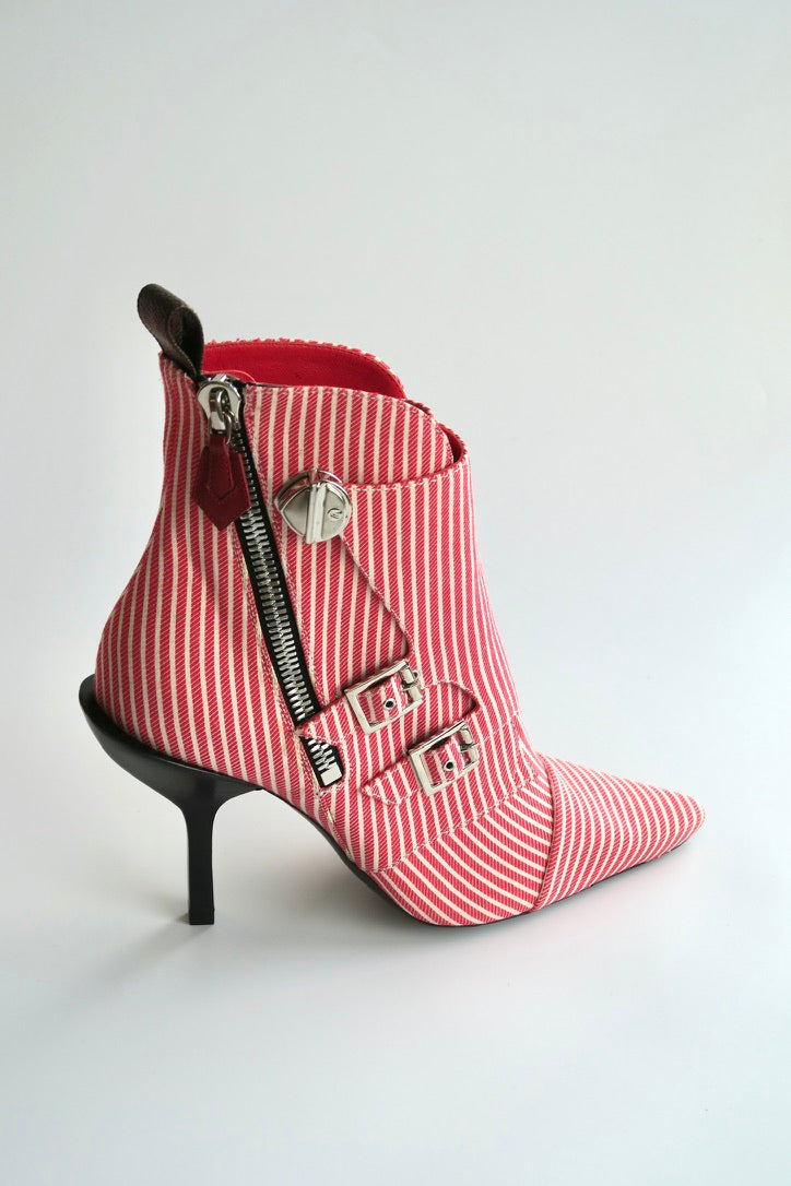 Red and white striped boot with a zipper on a light gray background