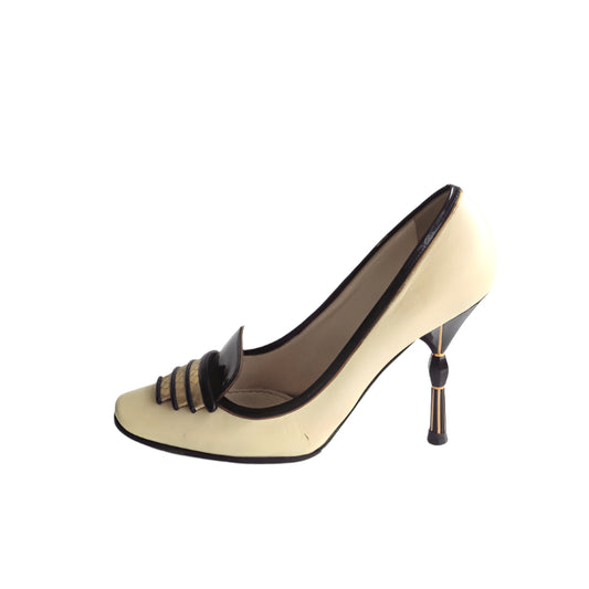 Beige high-heeled shoe with black accents on a white background
