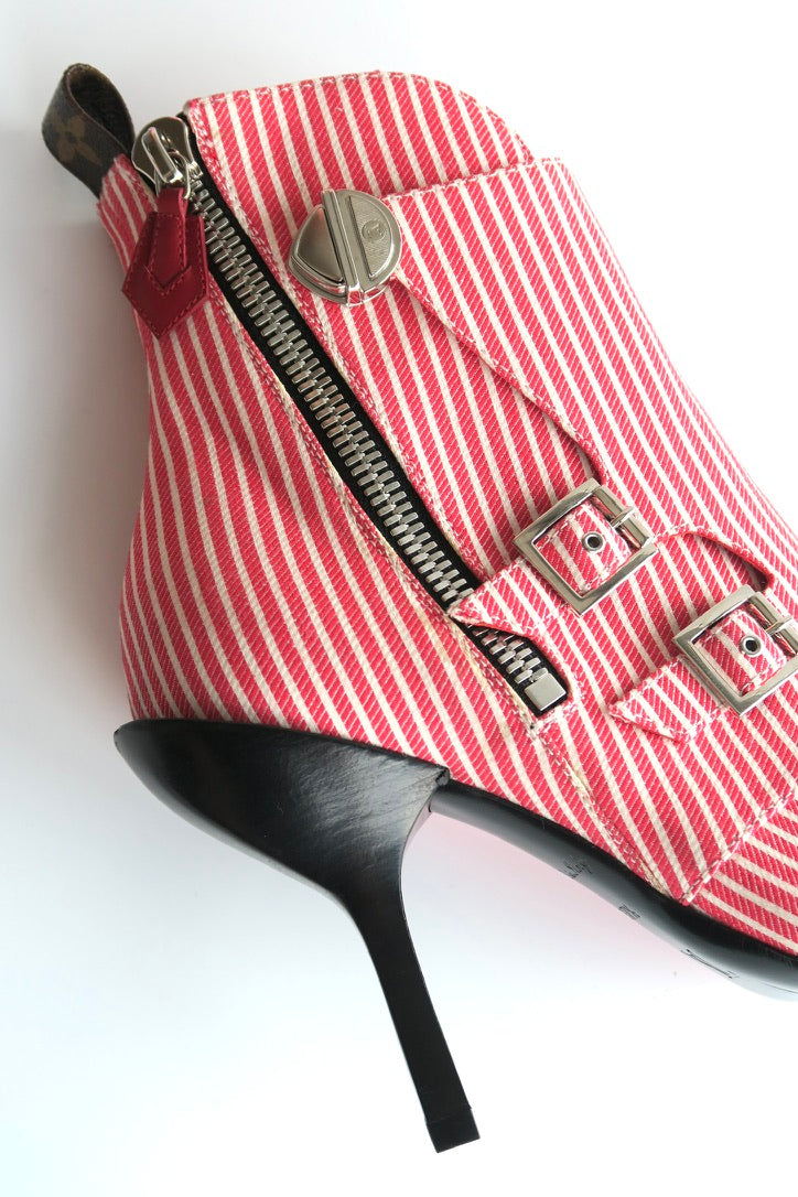 Red and white striped shoe with a black heel on a white background